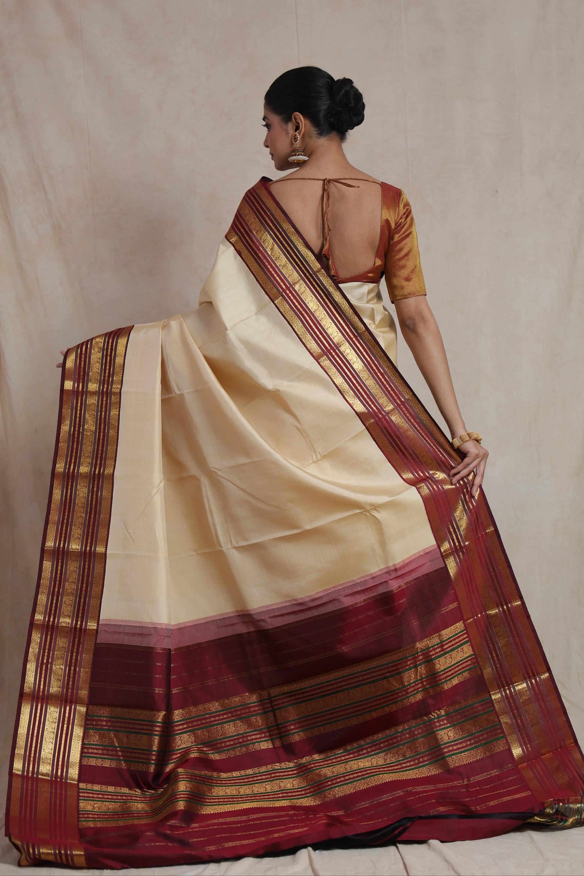 Back view of ivory Kanjivaram pure silk saree showcasing richly woven maroon pallu and classic border design