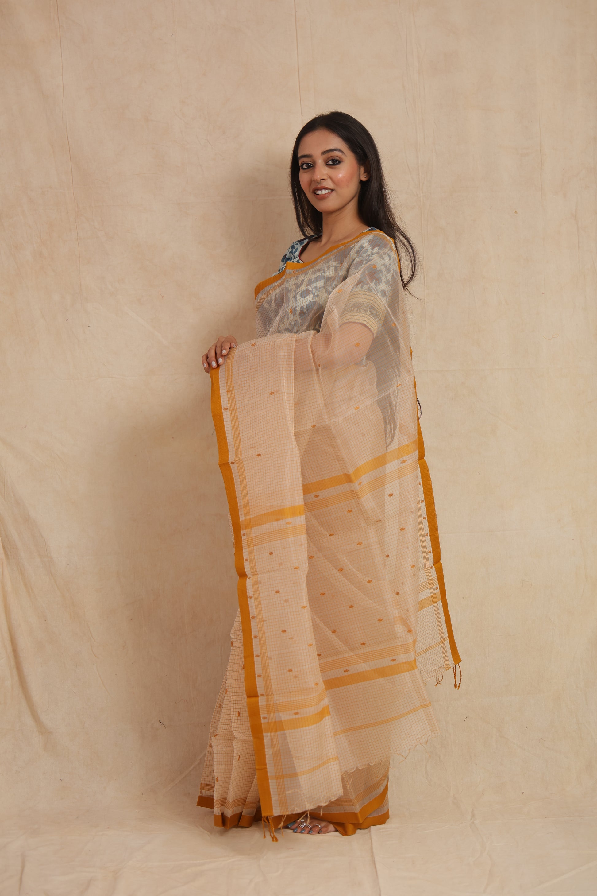 Side profile of ivory Maheshwari cotton saree with mustard woven border