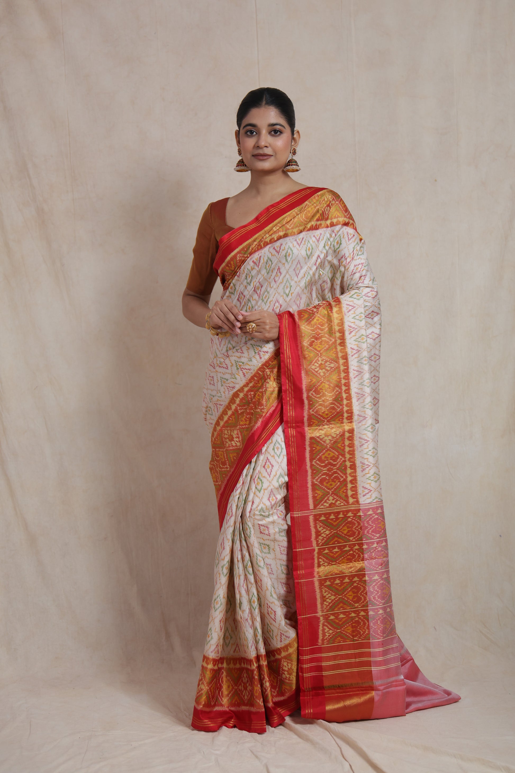 Full-length view of ivory white Patola handloom silk saree with ornate red woven border and pallu