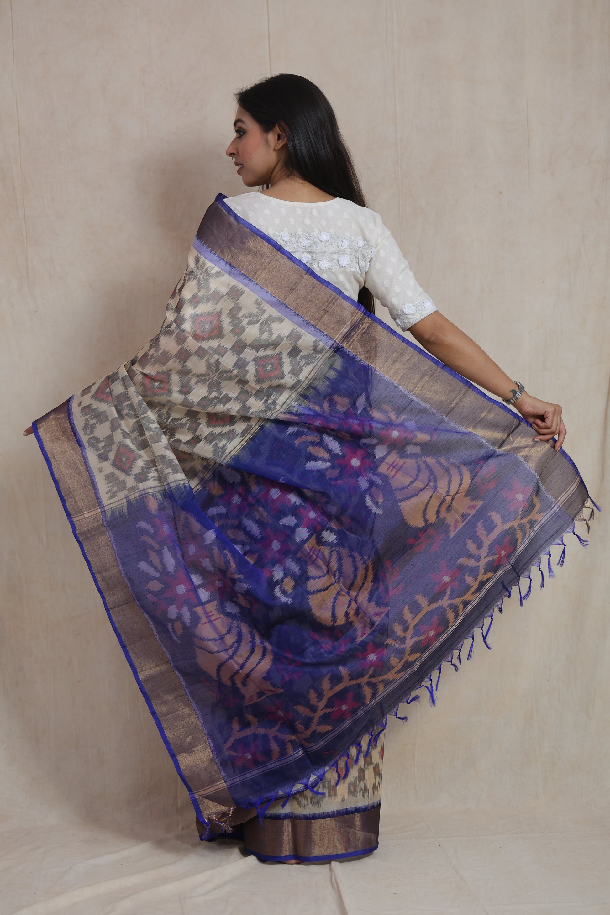 Back view of ivory Panchampali handloom silk cotton saree with traditional Ikat motifs and royal blue floral pallu