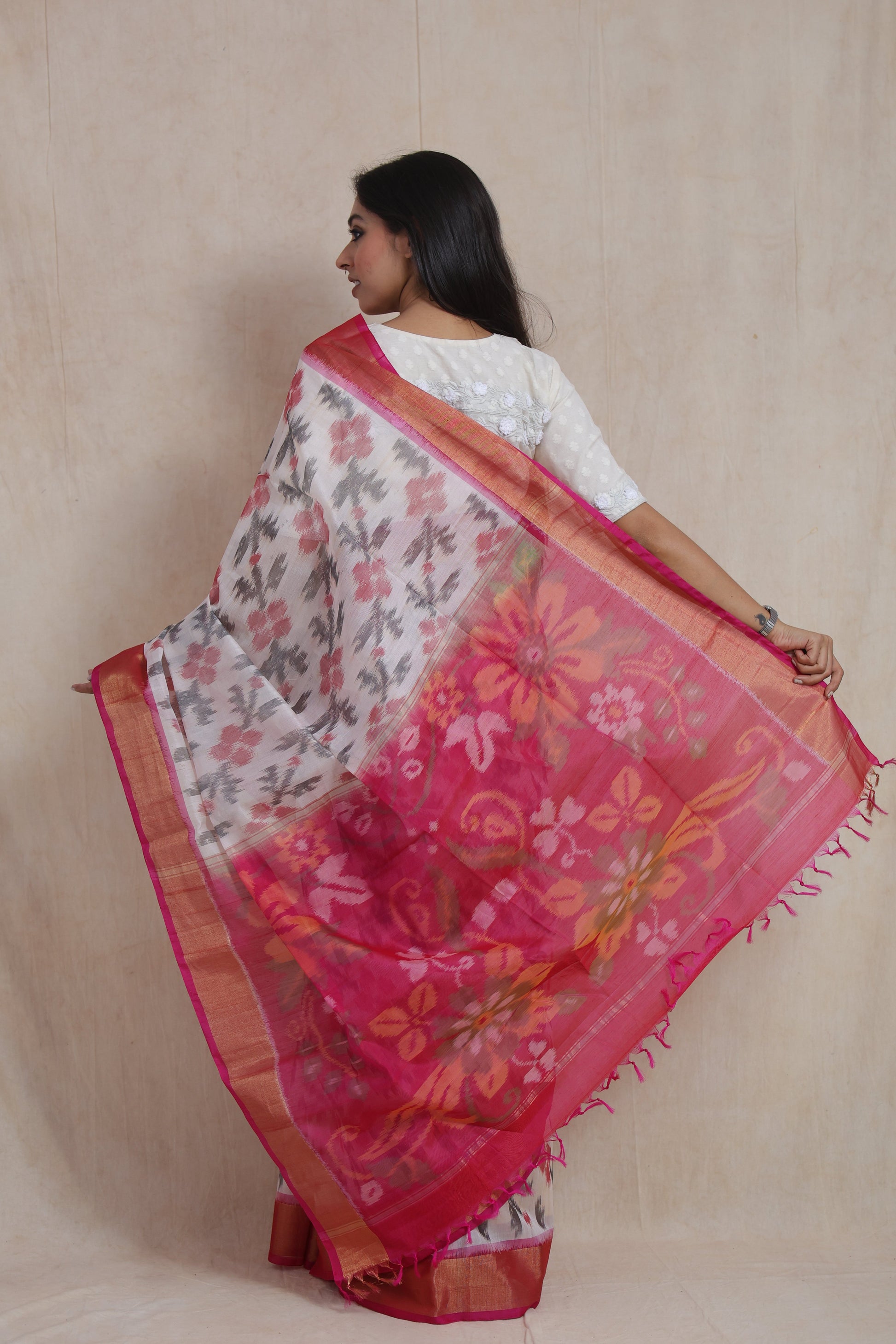 Back view of ivory Pochampally handloom silk cotton saree with floral Ikat motifs and vibrant pink floral pallu