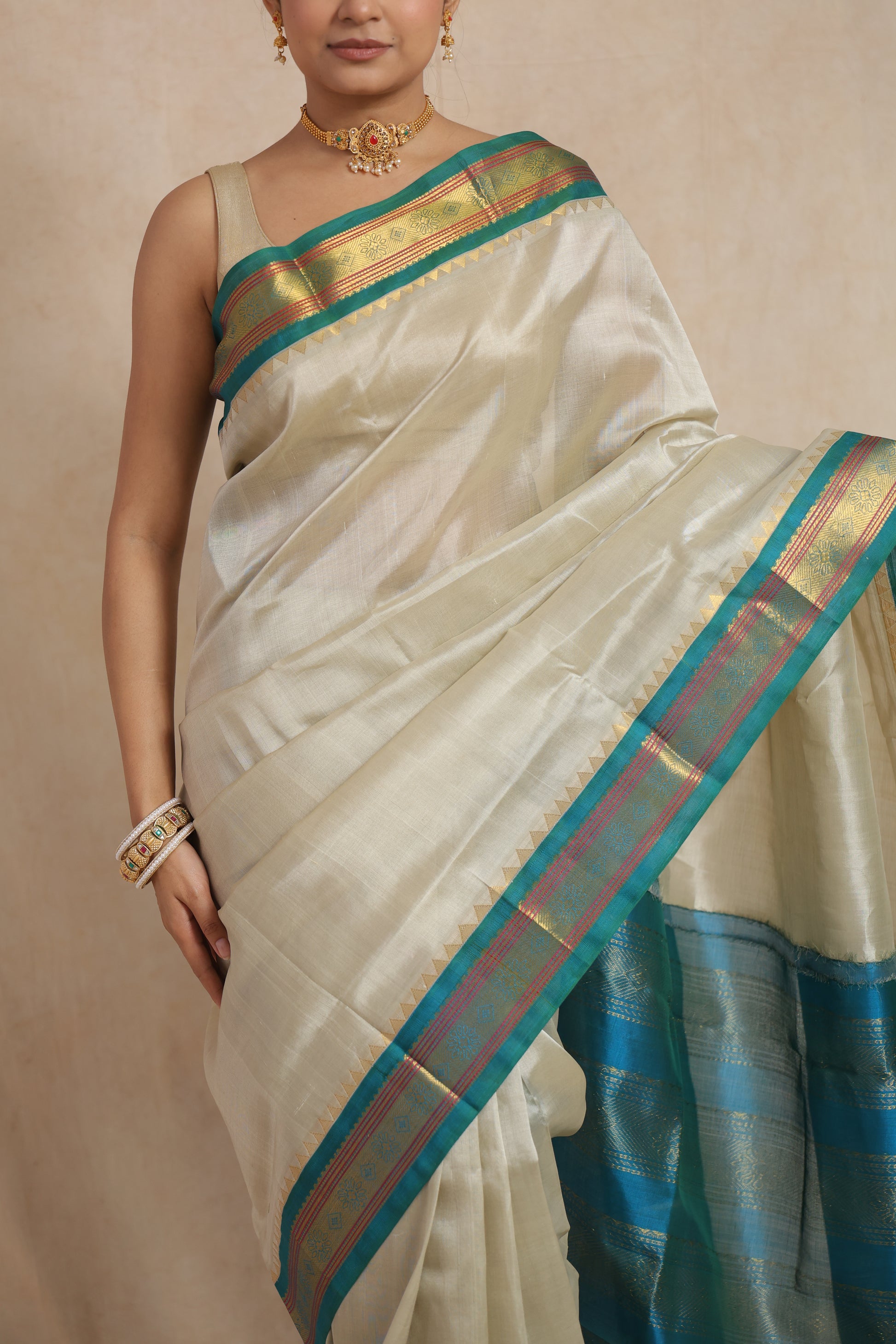 Close-up of ivory white Kanchipuram Sico saree with teal blue woven border