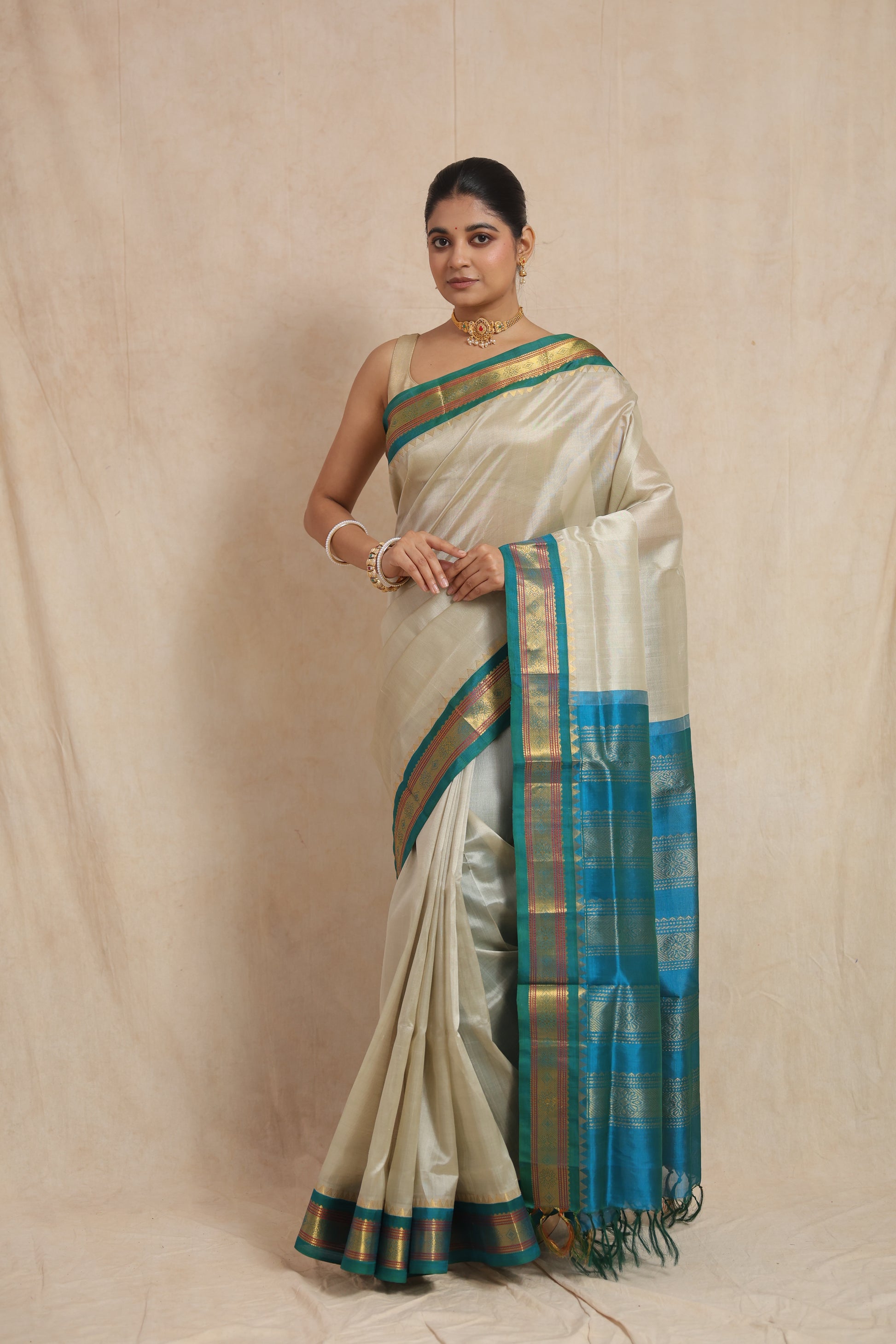 Full drape view of ivory white Kanchipuram Sico saree with teal blue pallu