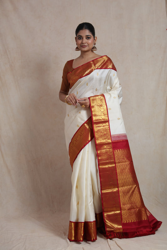 Model wearing ivory white Kanjivaram pure silk saree with elegant red border and traditional pallu