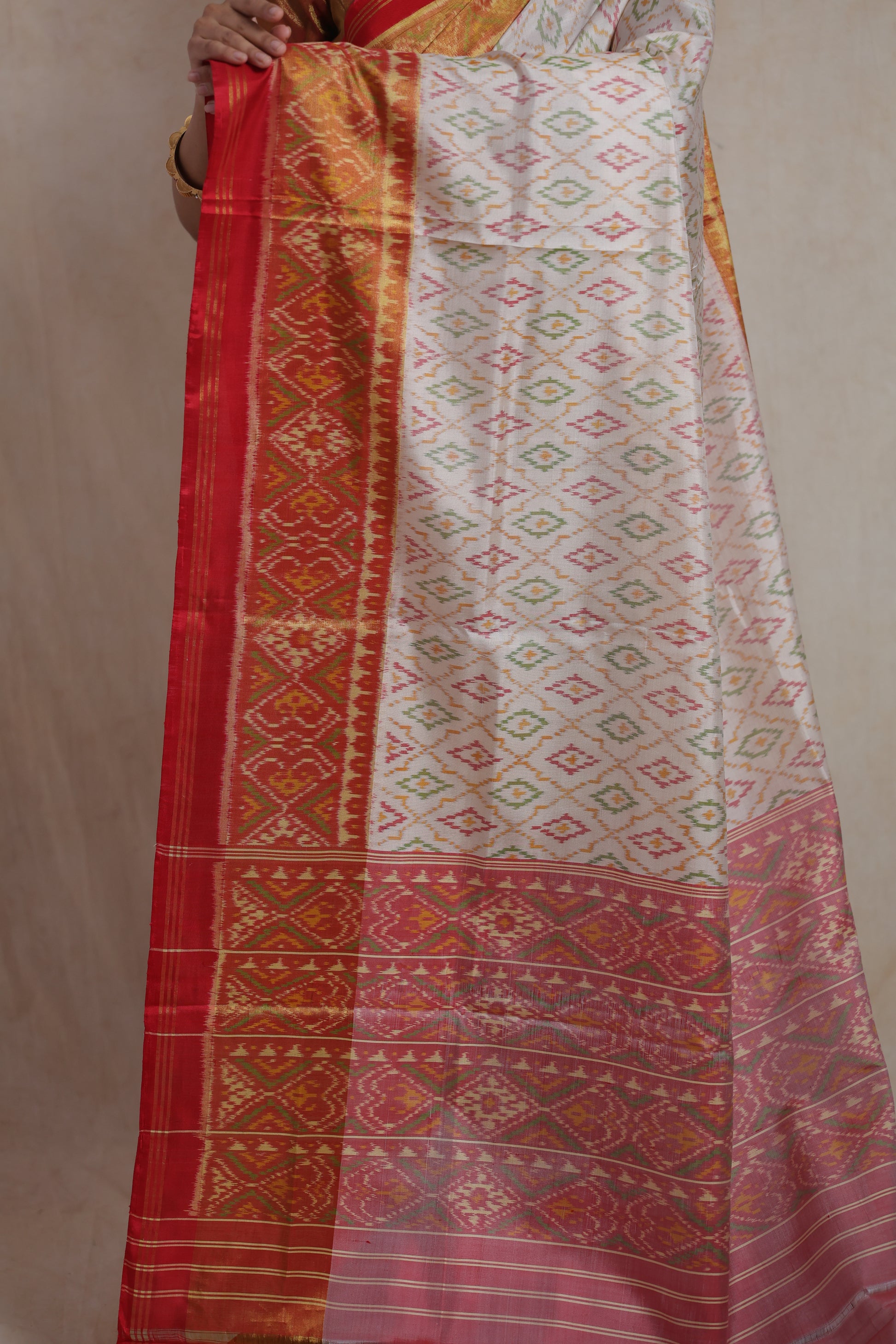 Detailed view of Patola handloom silk saree pallu with intricate traditional woven patterns and red border