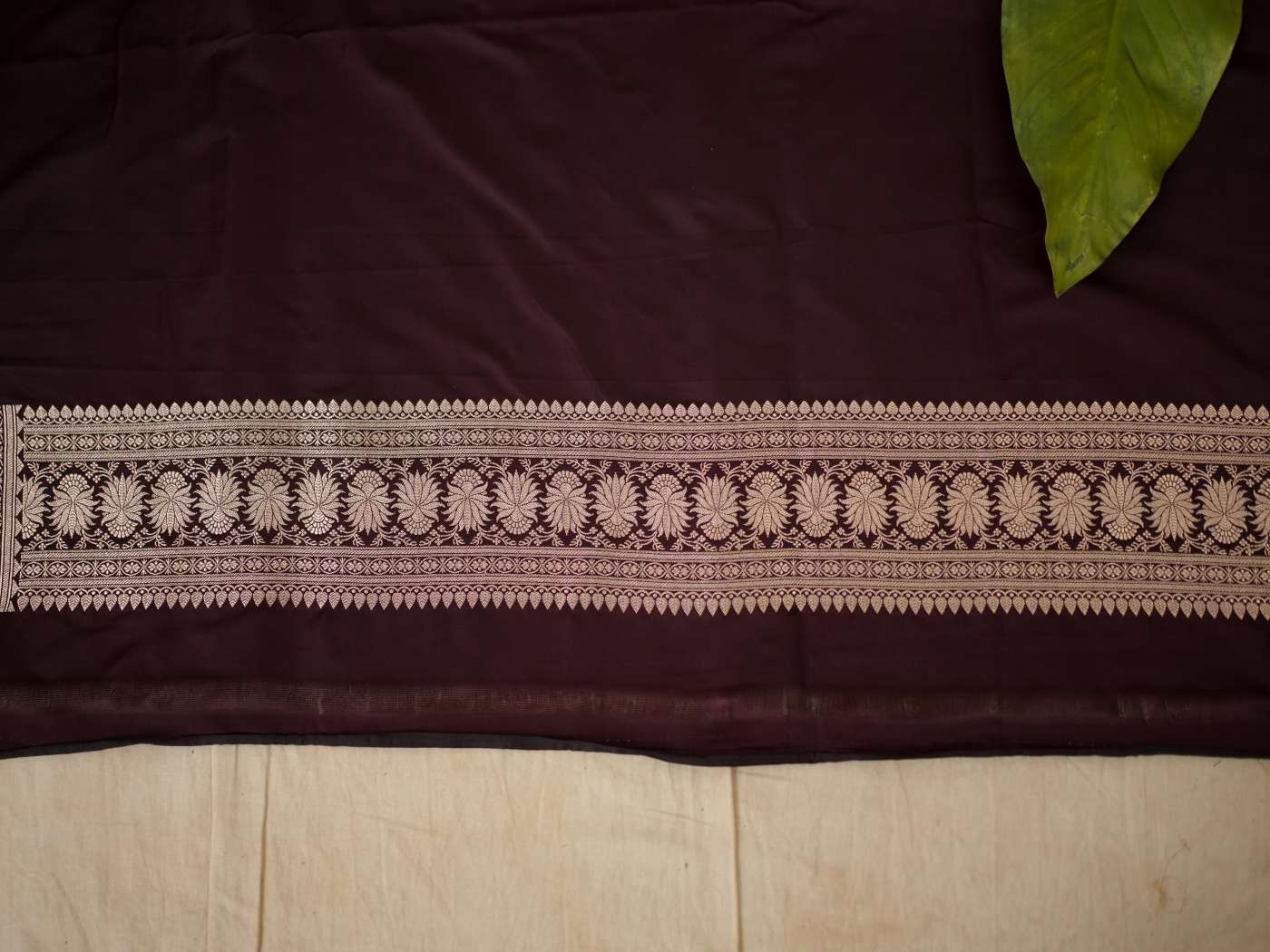 Dark brown Benarasi semi-silk saree with intricate gold zari work and matching blouse piece, handcrafted by Joyee Kolkata.