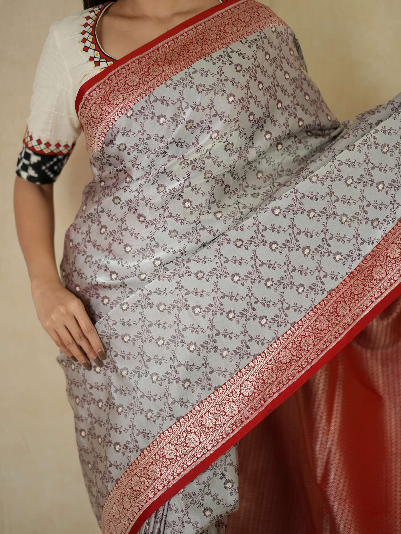 Grey semi Benarasi silk saree with intricate patterns and matching blouse piece from Joyee Kolkata, displayed draped on a mannequin.