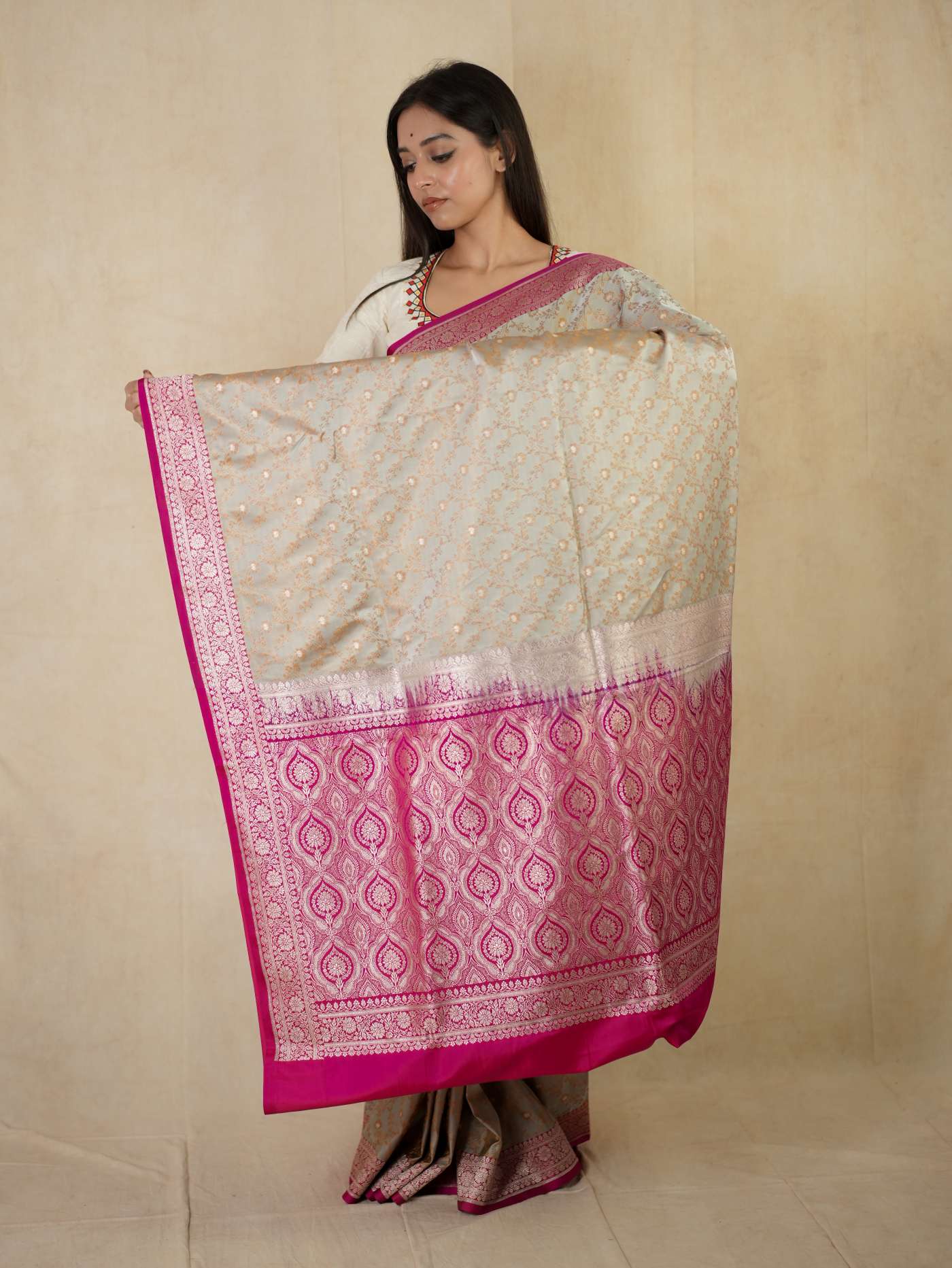 Grey semi Benarasi silk saree with intricate patterns and matching blouse piece from Joyee Kolkata, displayed flat on a white background.