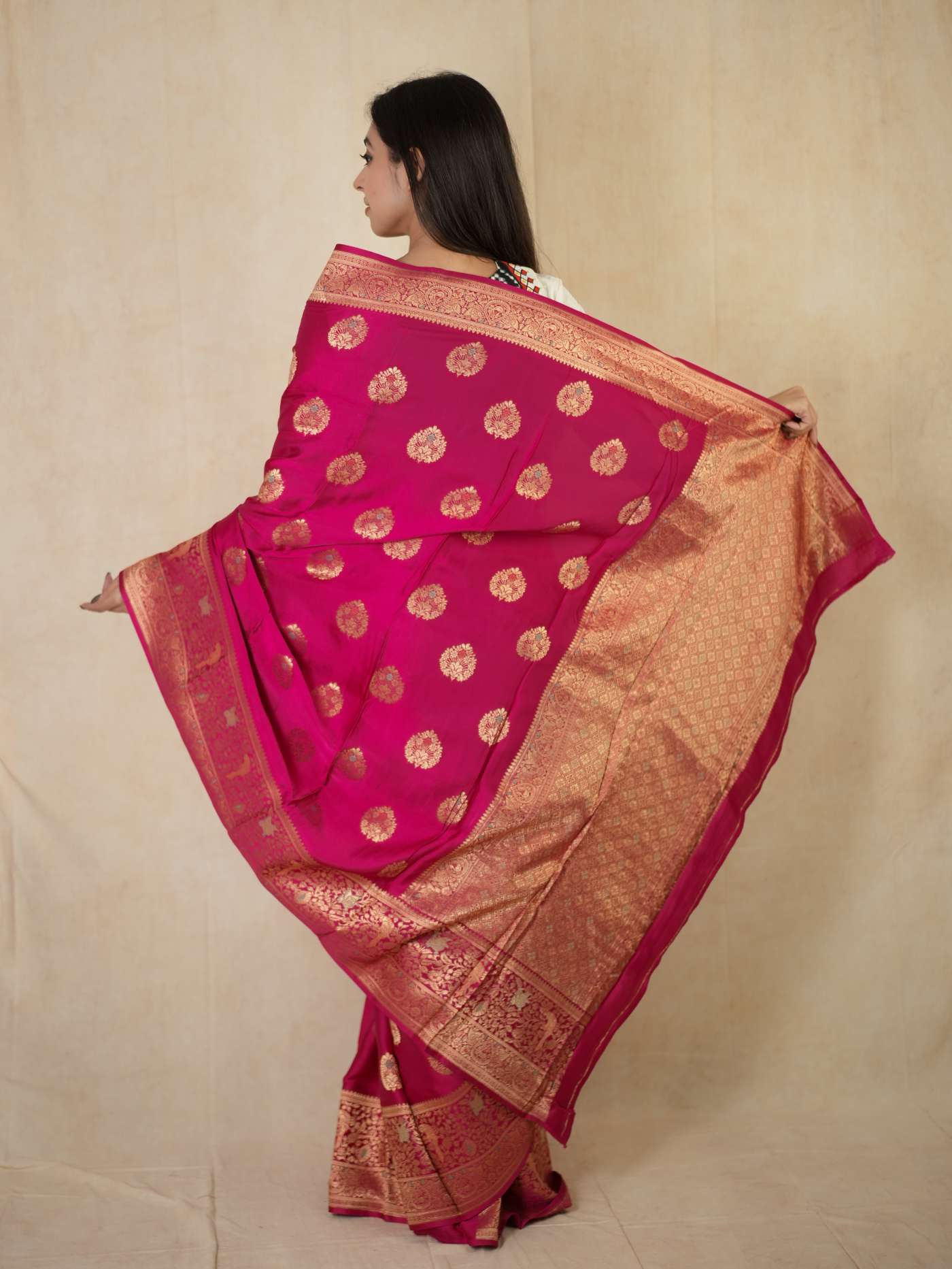 Magenta semi-silk Benarasi saree with intricate gold embroidery and matching blouse piece from Joyee Kolkata.
