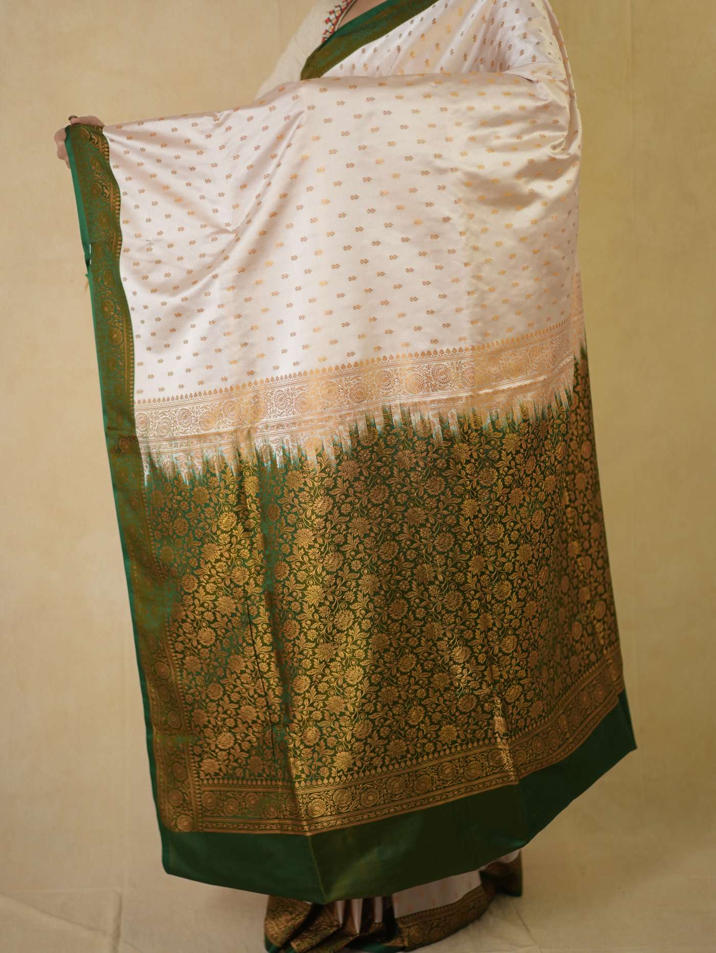 Cream semi Benarasi silk saree by Joyee Kolkata with intricate design and 88 cm blouse piece, displayed on a hanger.