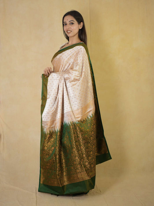 Cream semi Benarasi silk saree with intricate designs, paired with an 88 cm blouse piece from Joyee Kolkata.
