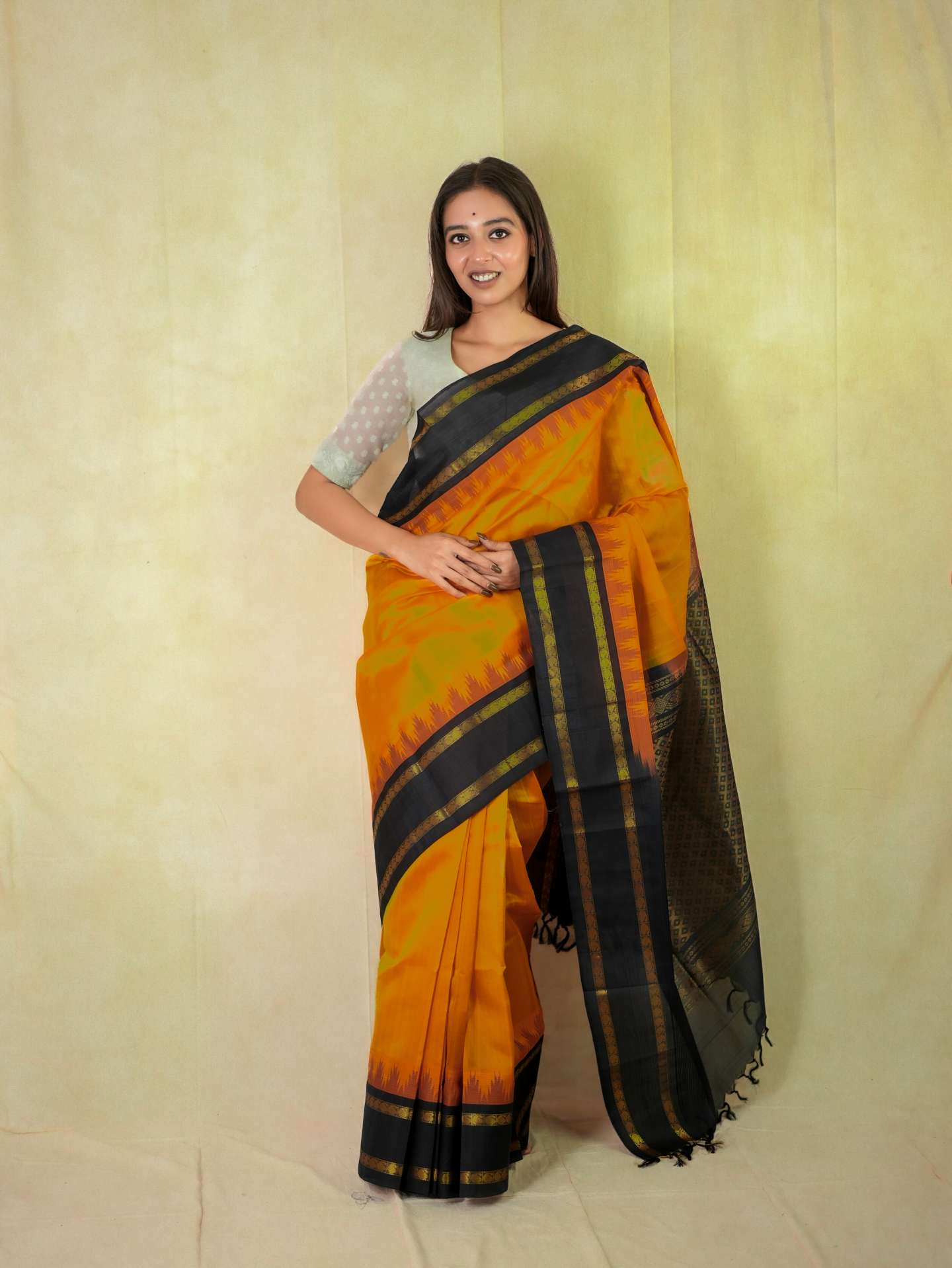 Orange Kanchipuram silk saree by Joyee Kolkata with intricate patterns and an 86 cm matching blouse piece.