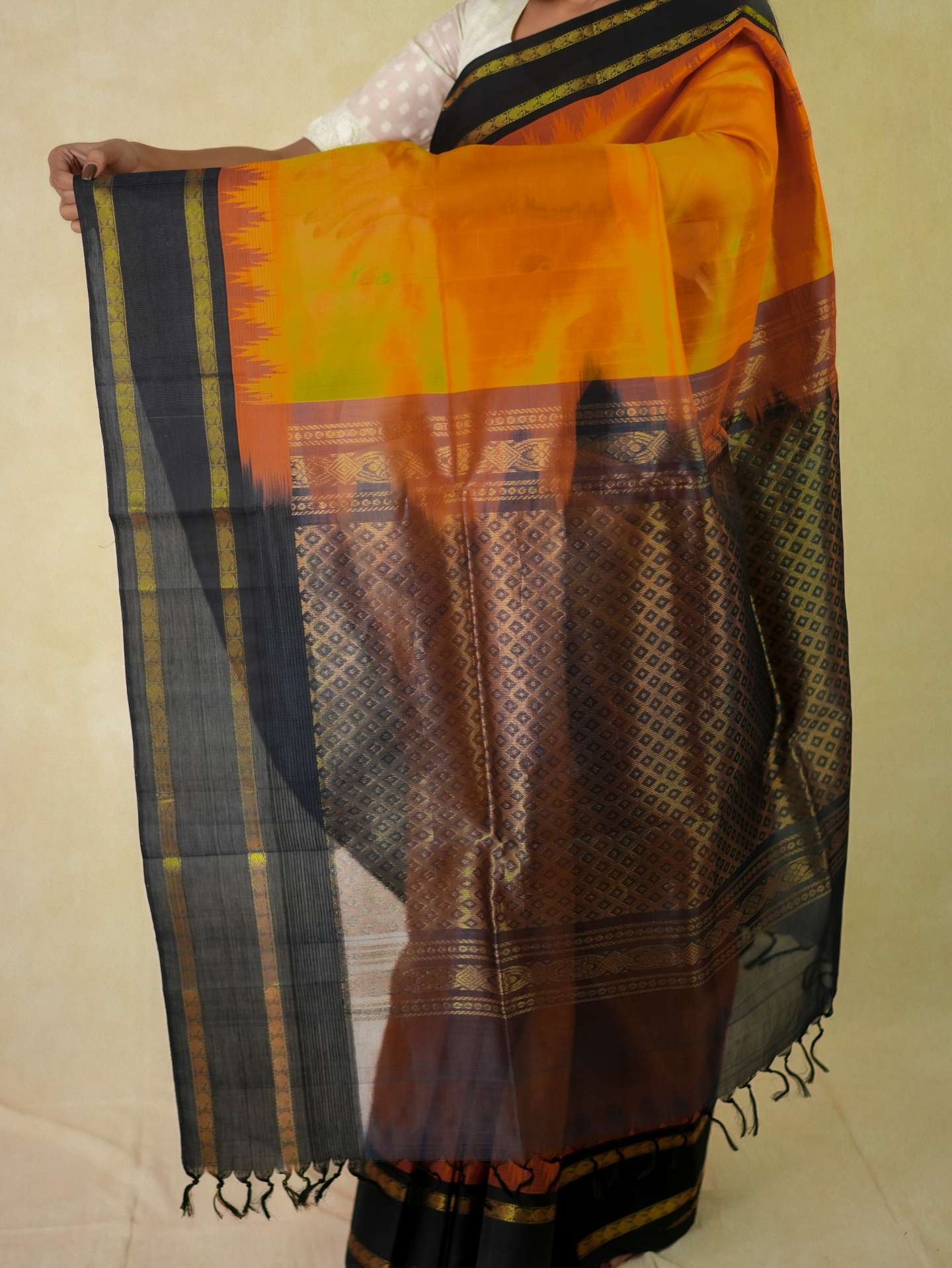 Orange Kanchipuram silk saree by Joyee Kolkata with matching blouse piece, featuring traditional gold zari work and intricate border.