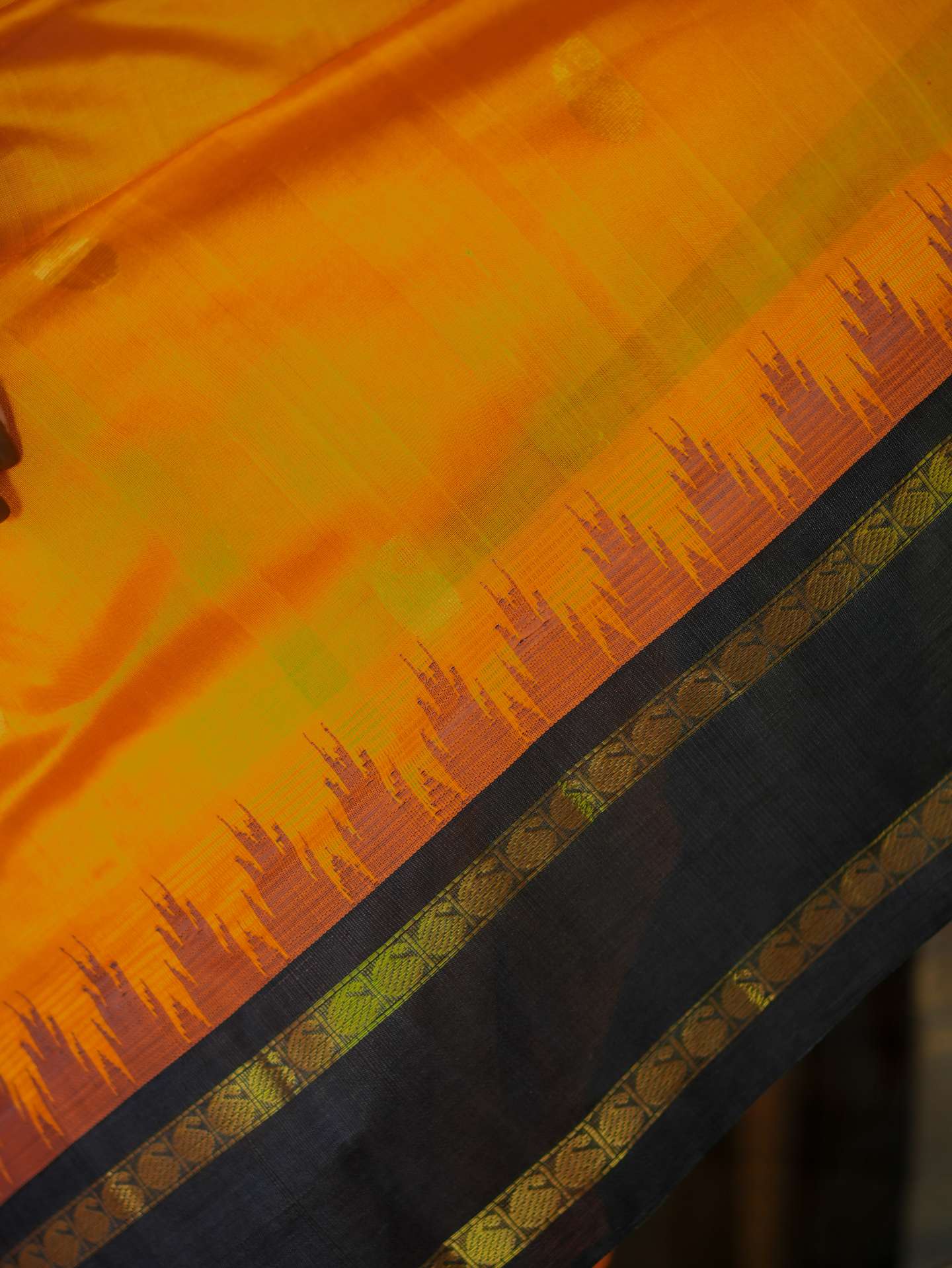 Orange Kanchipuram silk saree with matching blouse piece, featuring intricate traditional patterns and vibrant color.