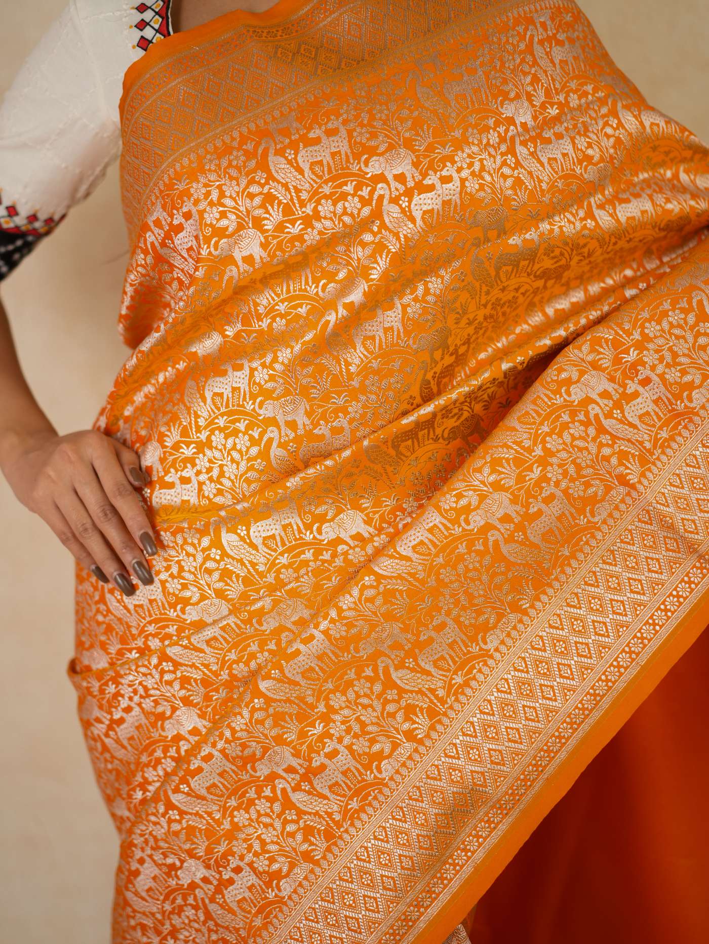 Orange semi Benarasi silk saree with intricate patterns and a matching blouse piece from Joyee Kolkata.
