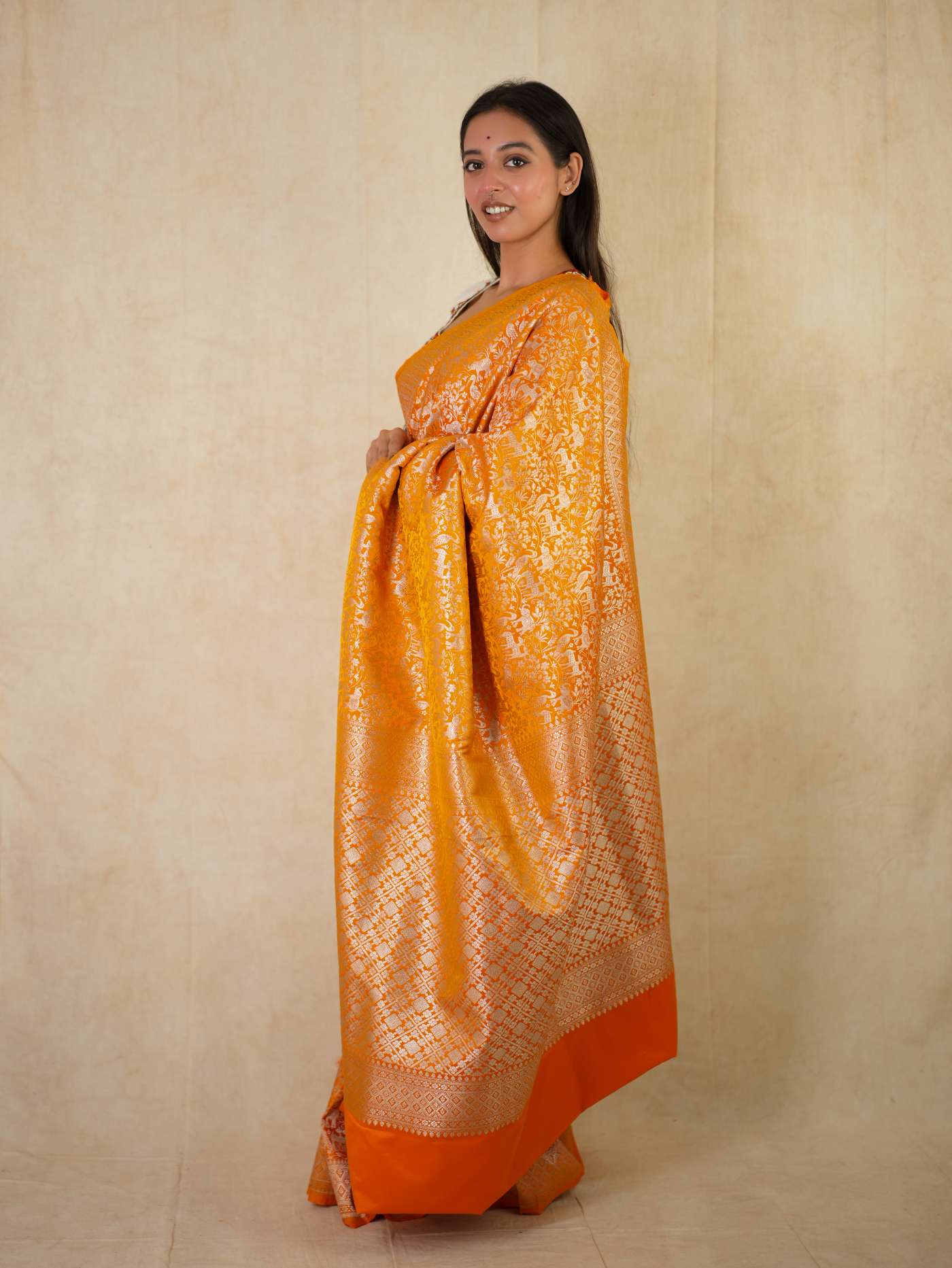 Orange semi Benarasi silk saree with intricate patterns and matching blouse piece, stylish traditional Indian attire by Joyee Kolkata.