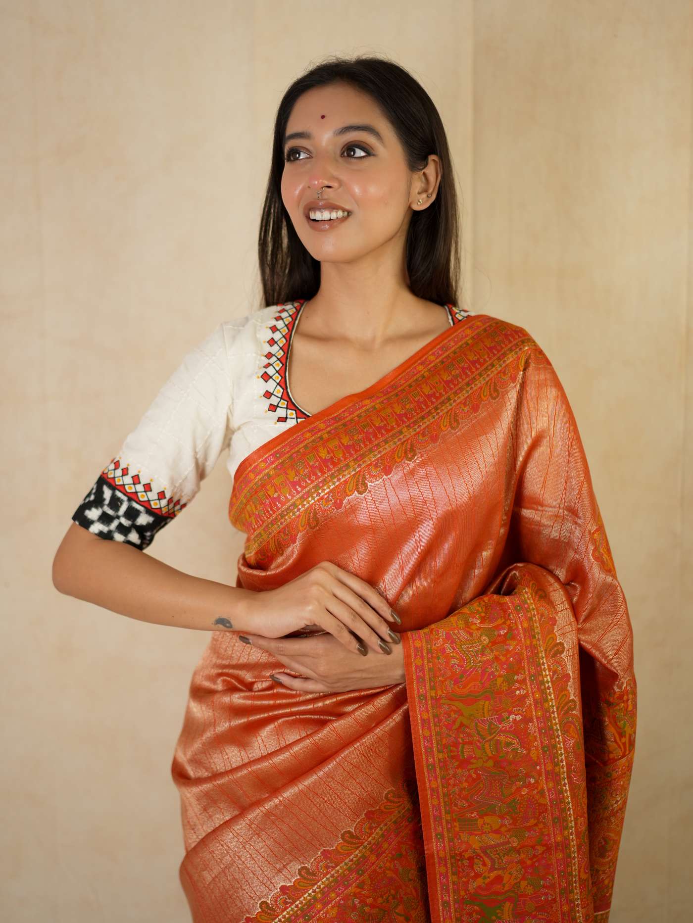Reddish orange semi Benarasi silk saree with intricate patterns and matching blouse piece, from Joyee Kolkata.