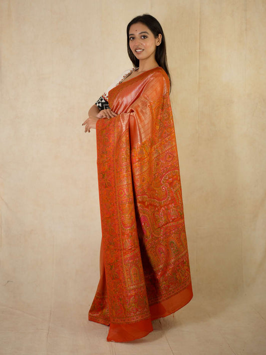 Reddish orange semi Benarasi silk saree with intricate patterns and matching blouse piece from Joyee Kolkata.