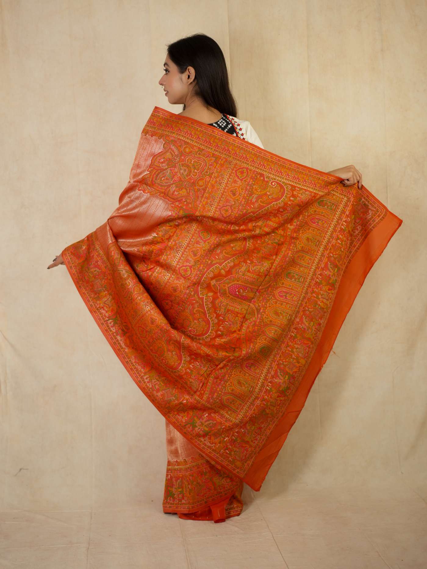 Reddish orange semi Benarasi silk saree with intricate patterns and matching blouse piece from Joyee Kolkata.