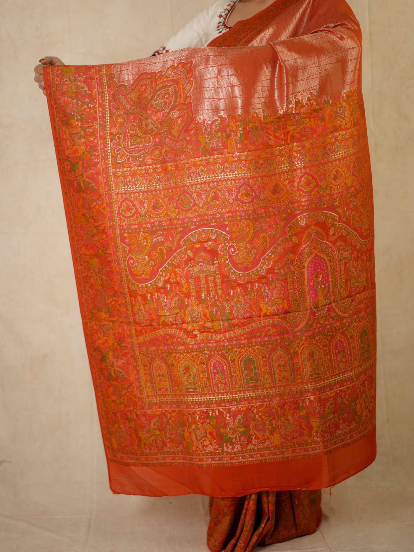 Reddish orange semi Benarasi silk saree with intricate patterns and matching blouse piece from Joyee Kolkata.