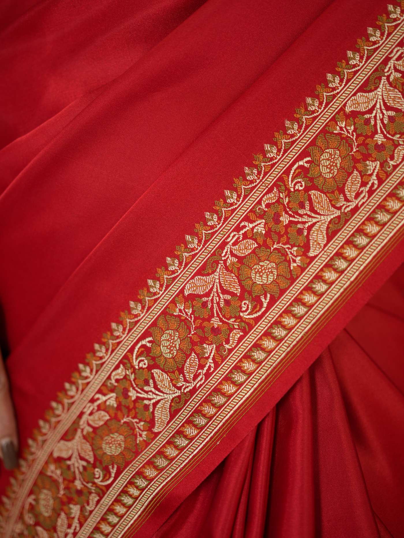 Rich red Benarasi semi-silk saree with intricate gold zari work and matching blouse piece displayed in the image.