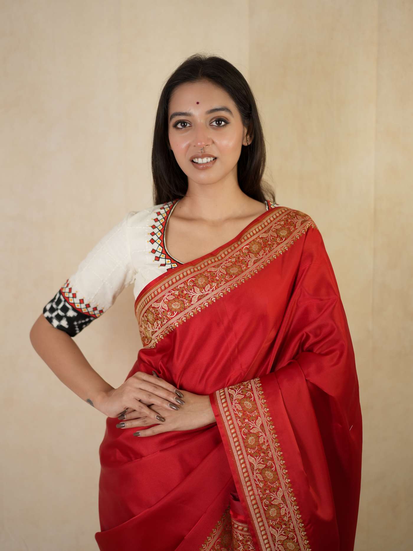 Rich red Benarasi semi-silk saree with intricate gold zari work and matching blouse piece, showcasing traditional Indian craftsmanship.