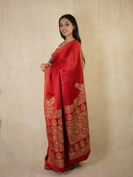 Rich red Benarasi semi-silk saree with intricate gold zari work and matching blouse piece from Joyee Kolkata.