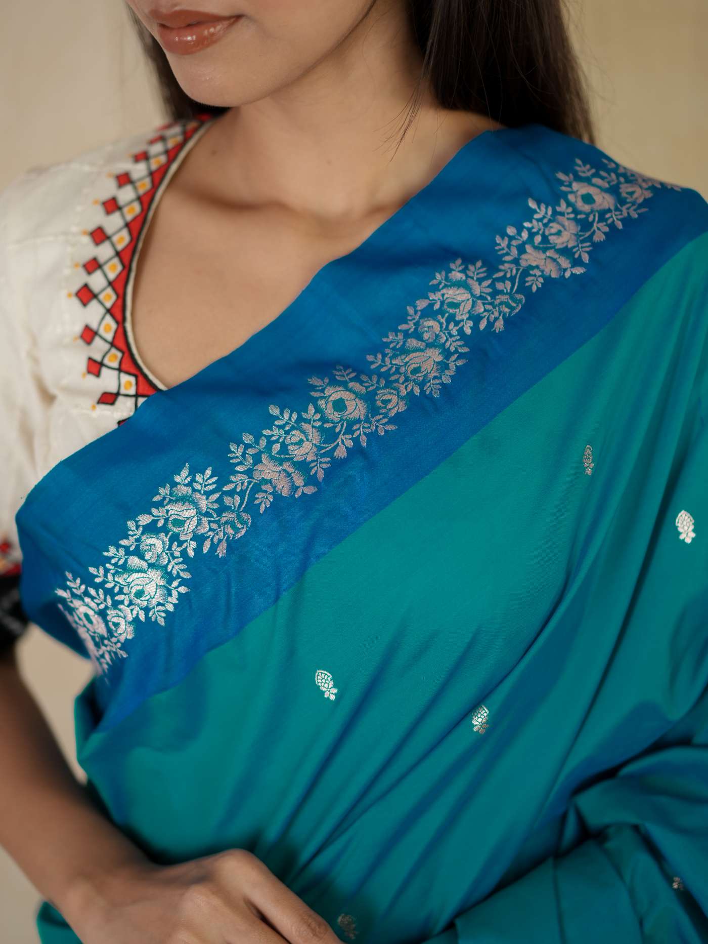 Turquoise blue semi-silk Benarasi saree with intricate patterns and matching blouse piece from Joyee Kolkata.