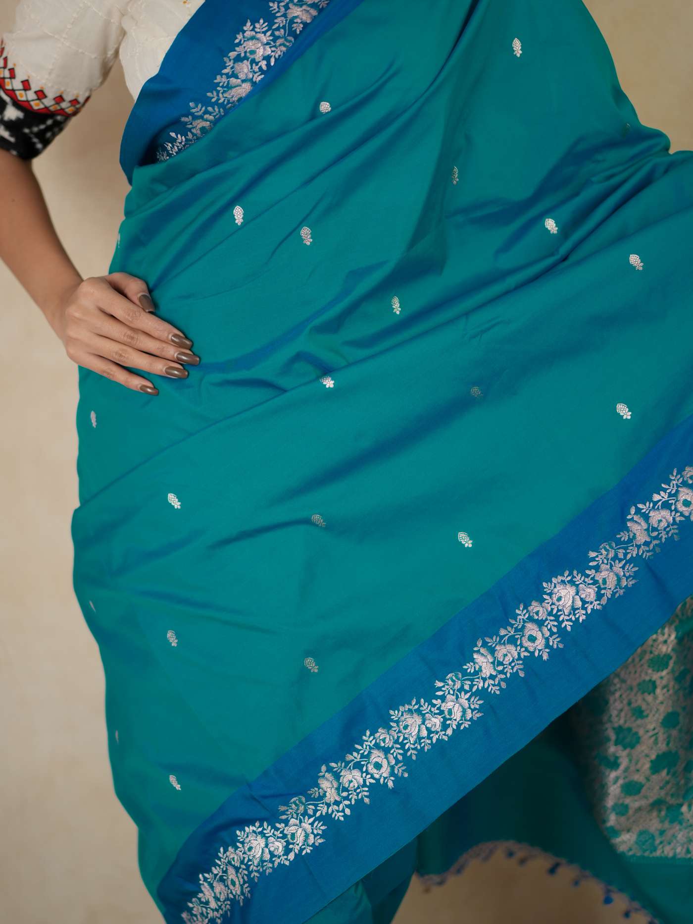 Turquoise blue semi-silk Benarasi saree with intricate patterns and matching blouse piece from Joyee Kolkata.