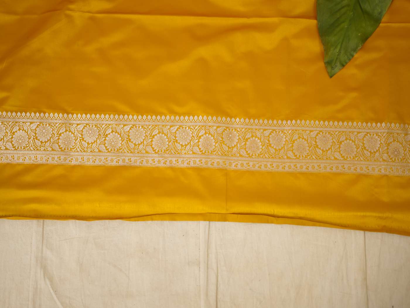 Yellow semi Benarasi silk saree with intricate patterns and matching blouse piece from Joyee Kolkata.