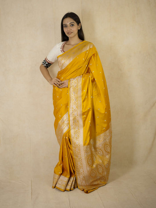 Yellow semi Benarasi silk saree with intricate designs and matching blouse piece by Joyee Kolkata, traditional Indian attire.