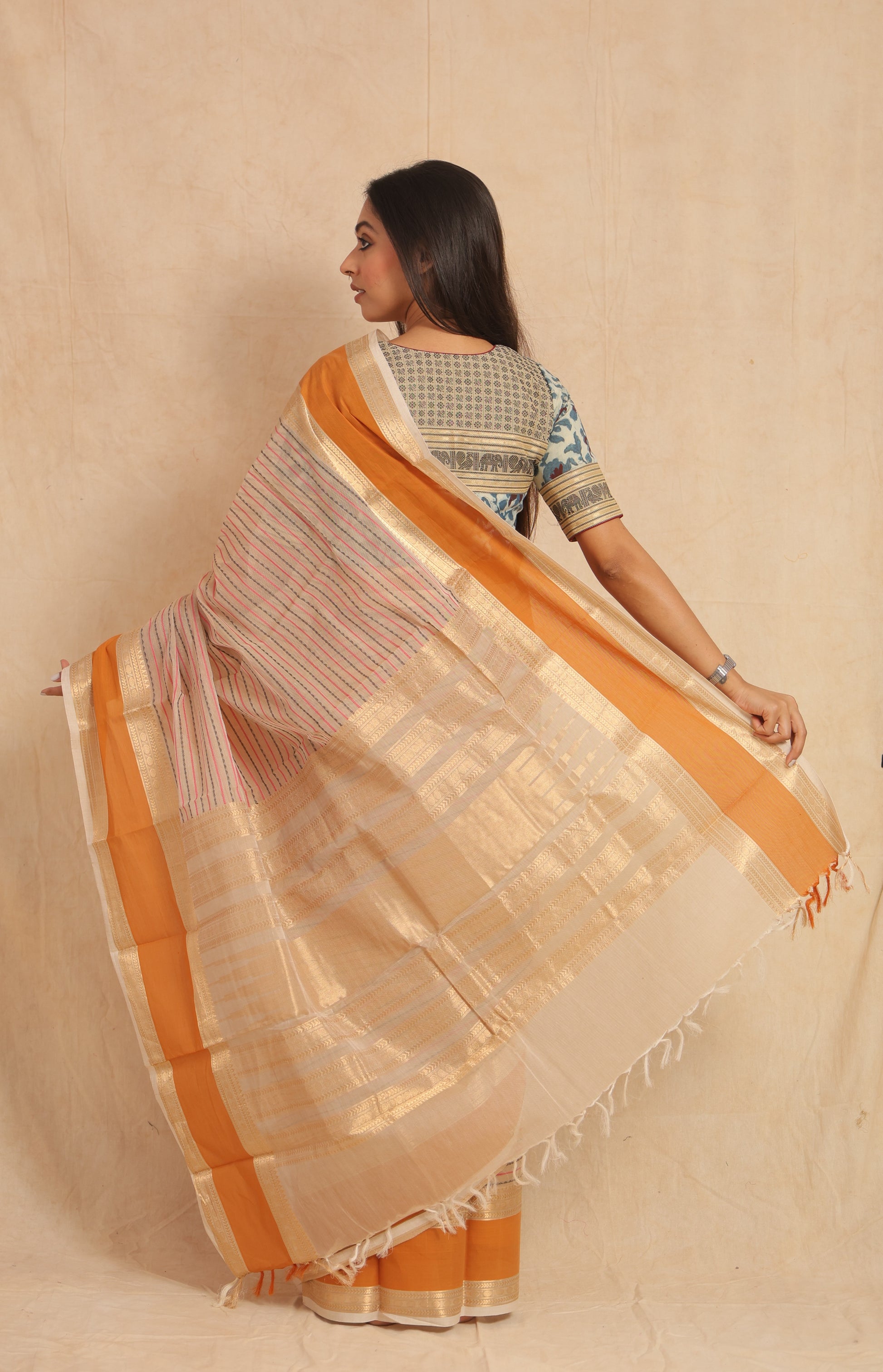 Detailed pallu of off white saree with rich zari and orange border