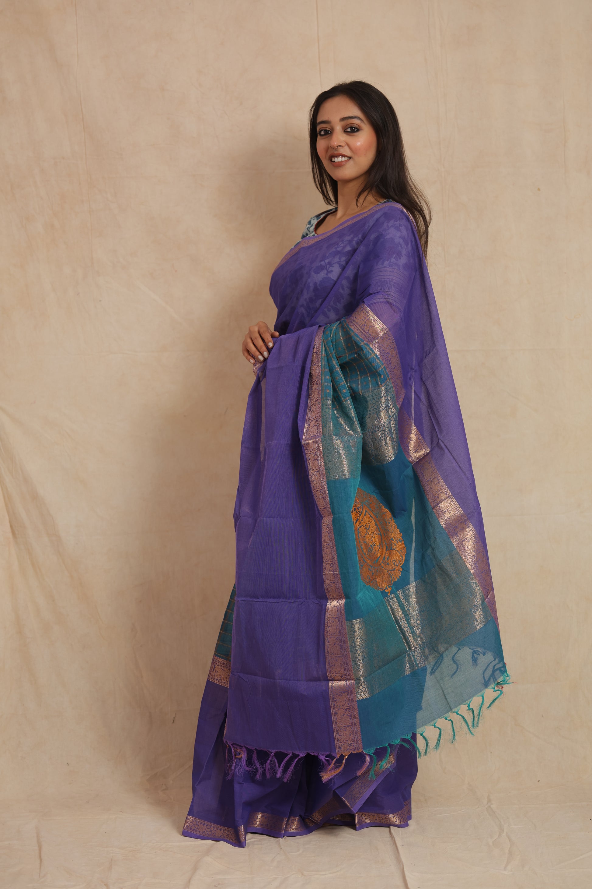 Side profile of purple Kanchipuram cotton saree with contrasting teal pallu and tassels