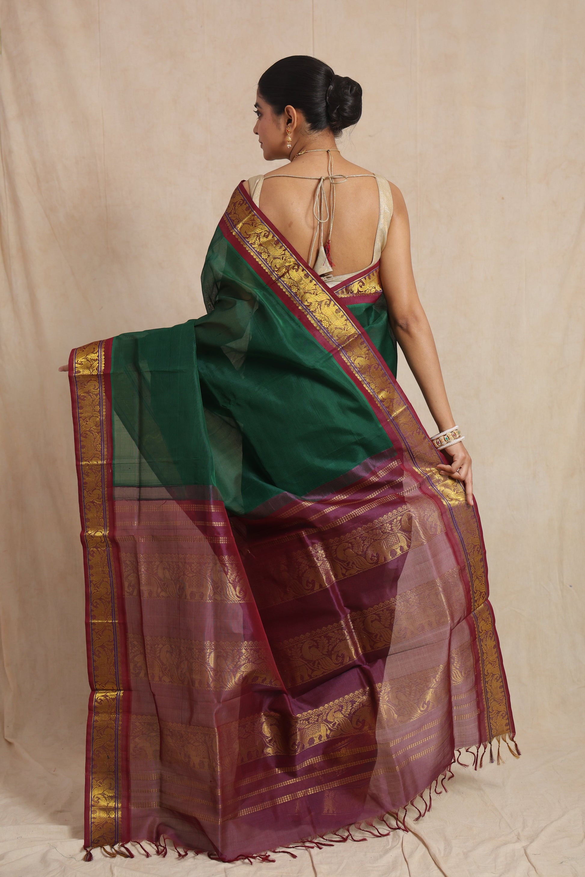 Back view of emerald green Kanchipuram SICO saree featuring a contrasting wine purple pallu with traditional motifs