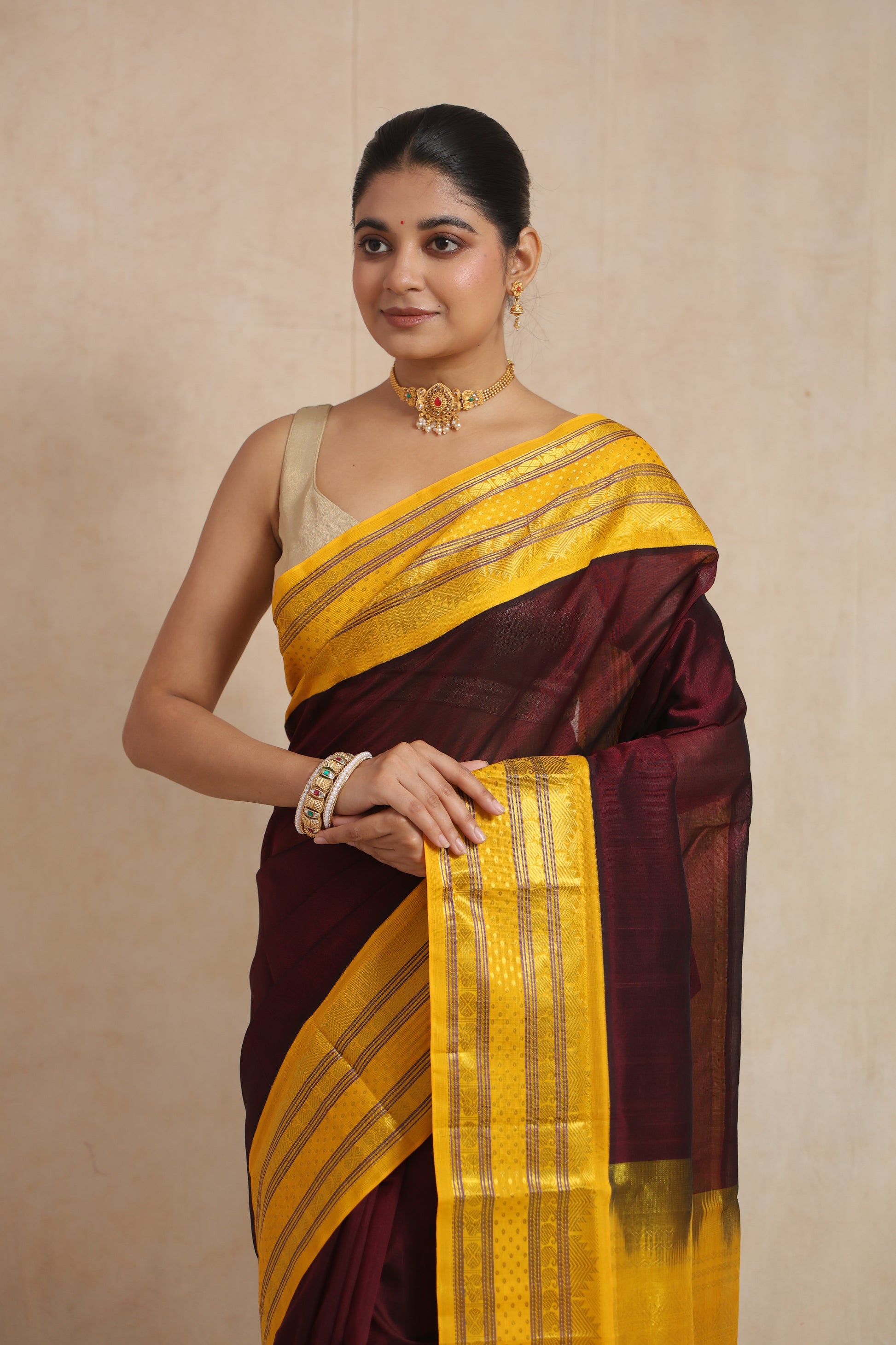 Close-up of maroon Kanchipuram SICO saree highlighting the rich yellow border and traditional woven patterns