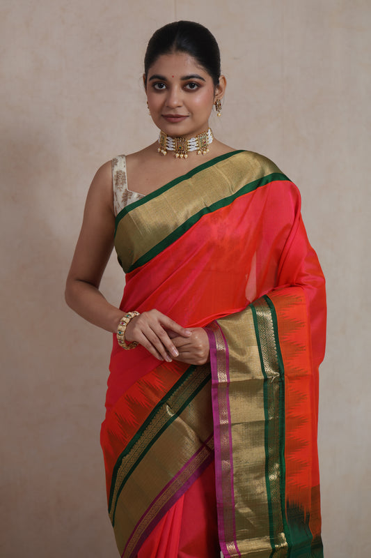 Closeup of coral red Kanchipuram silk cotton saree with rich zari woven border