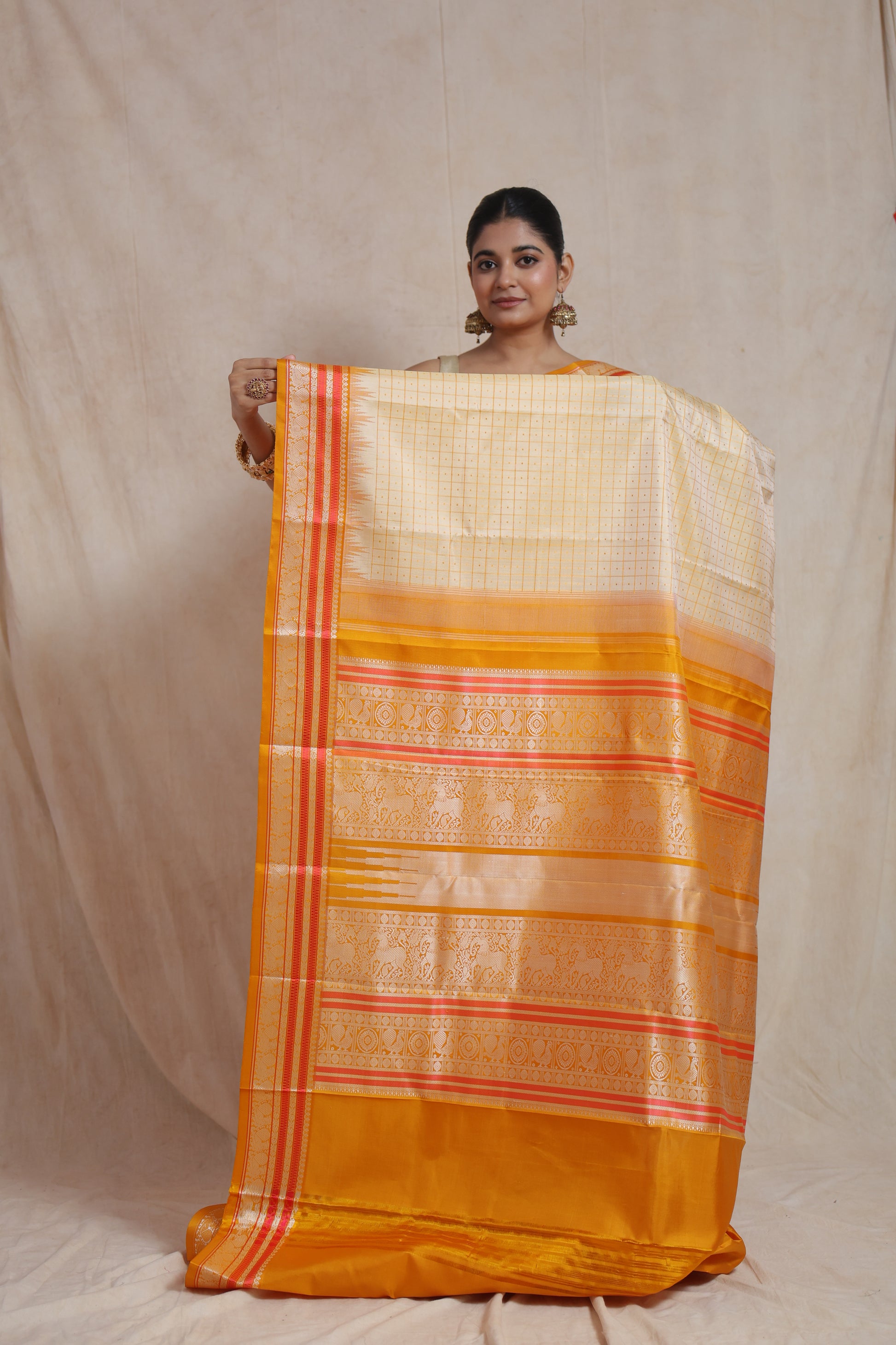 Saree fabric laid flat showing mustard blouse piece and border