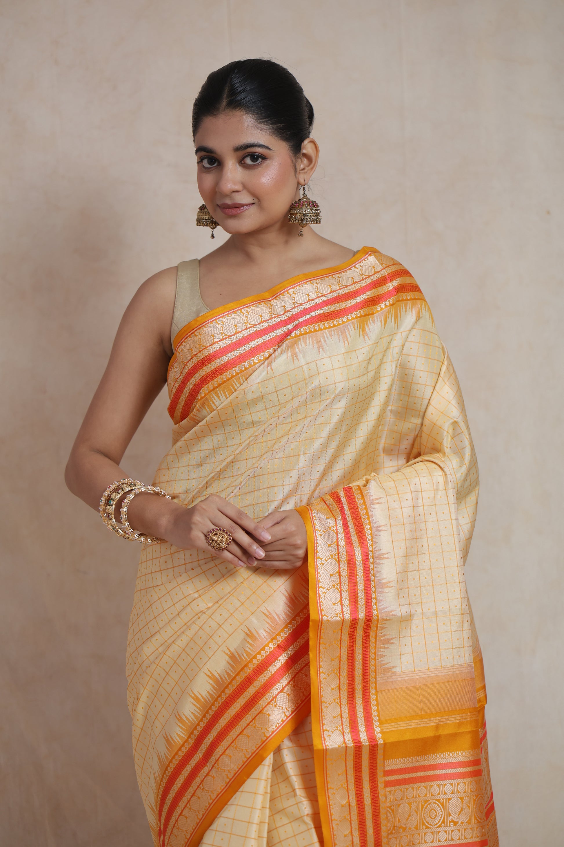 Elegant drape of cream saree with mustard and gold zari border