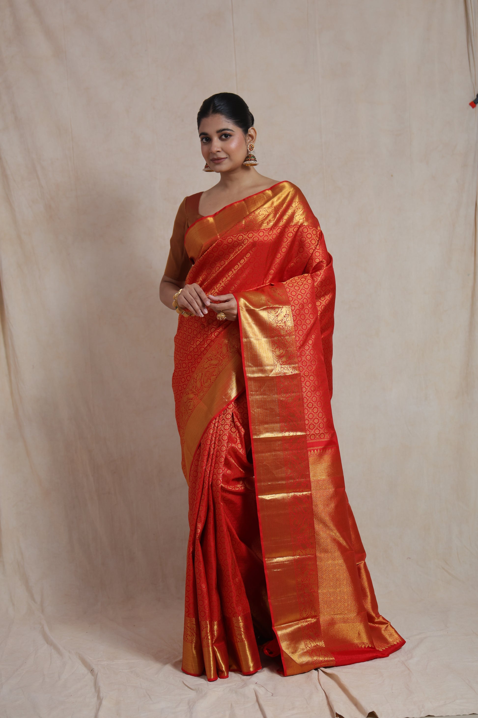 Elegant drape of red silk saree with traditional zari weaving