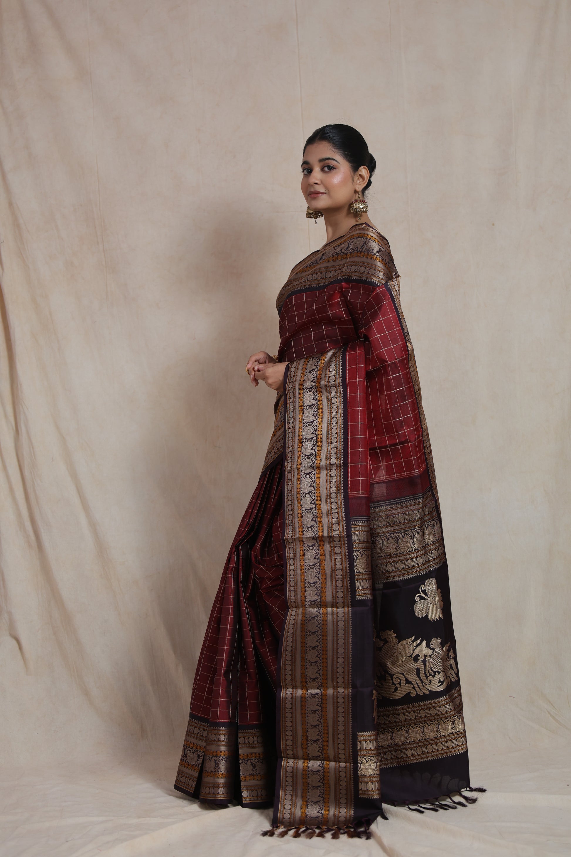 Artistic woven pallu on deep wine Kanjeevaram silk saree with antique zari motifs