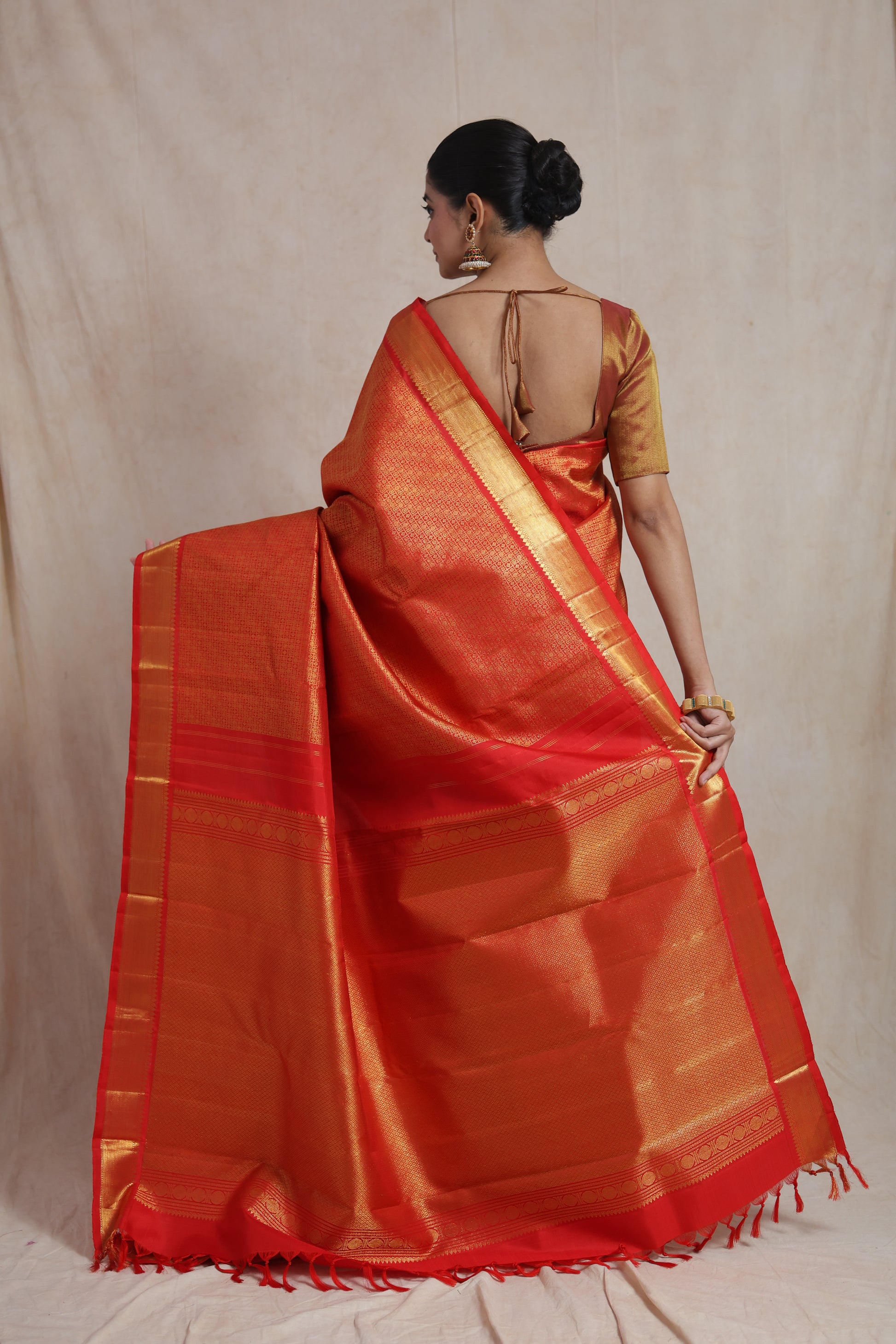 Back view of vermilion red Kanjivaram pure silk saree highlighting the grand woven pallu