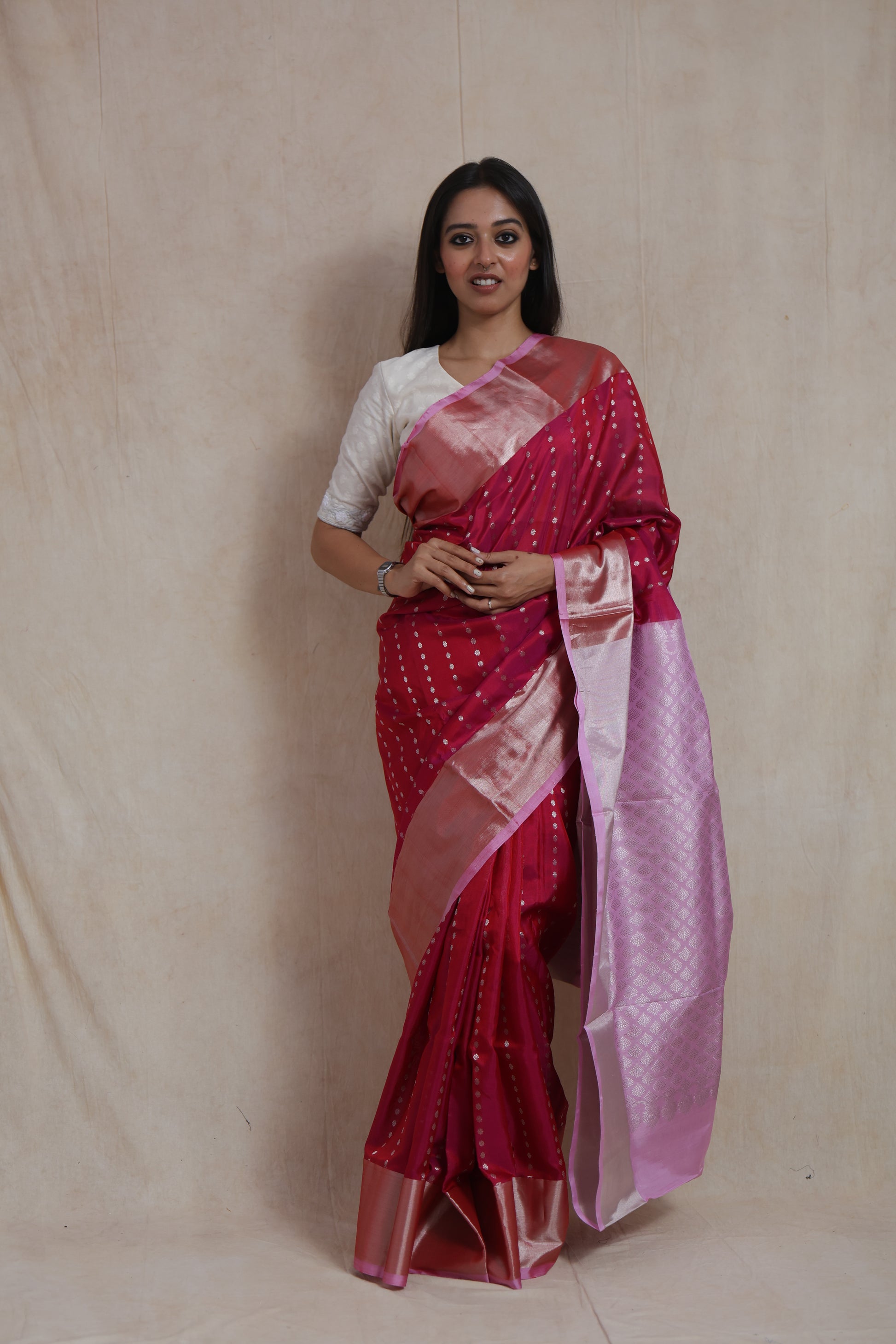 Close-up of silver woven motifs on rani pink Kanjivaram silk saree with shimmering border