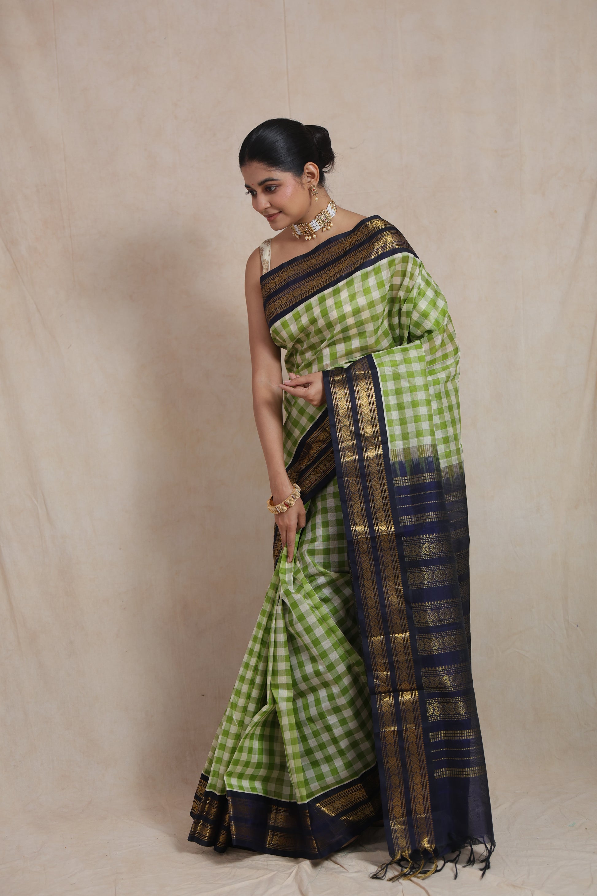 Styled look of lime green checked Kanchipuram Sico saree with navy blue zari border