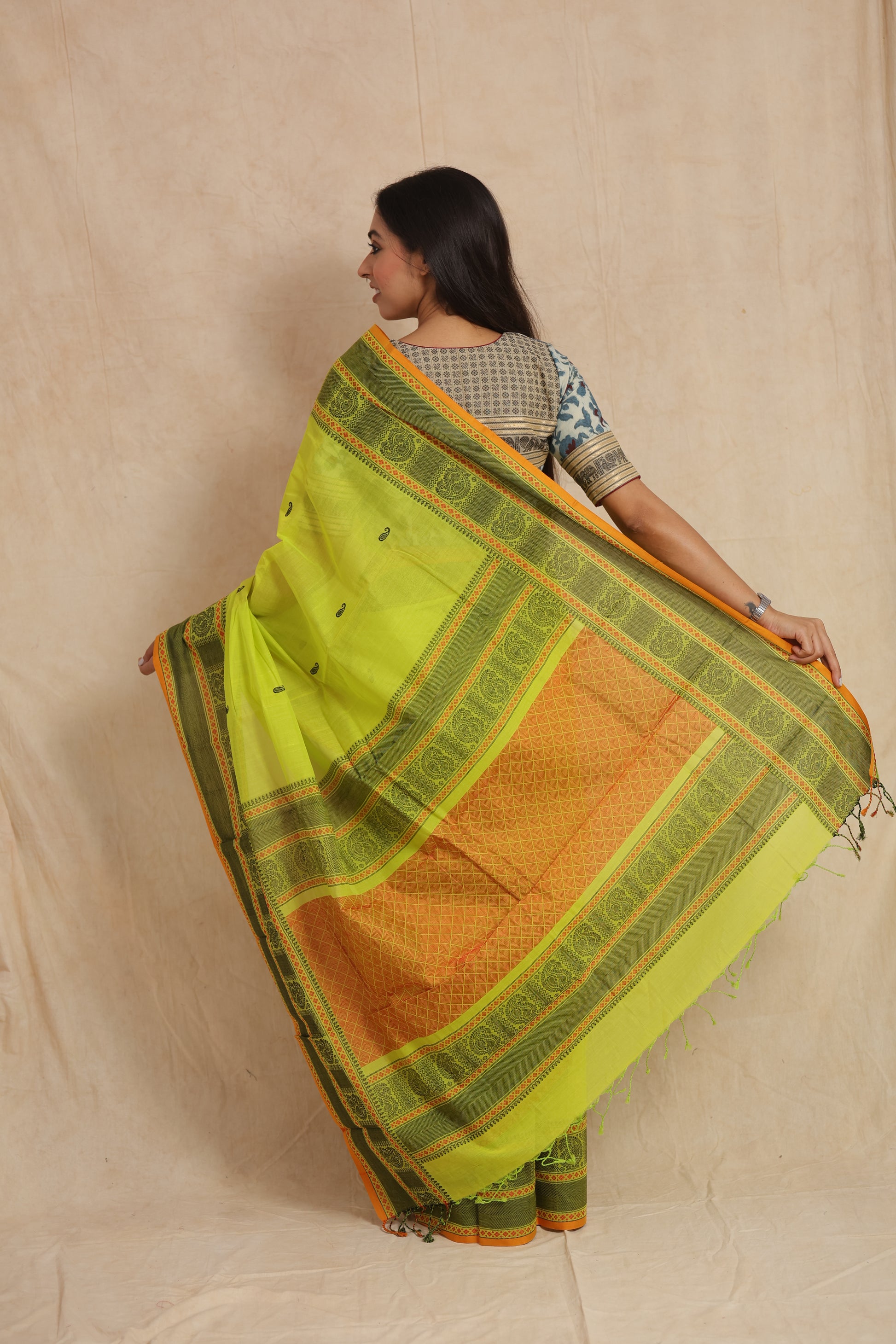 Back view of lime green Kanchipuram cotton saree showcasing detailed woven pallu