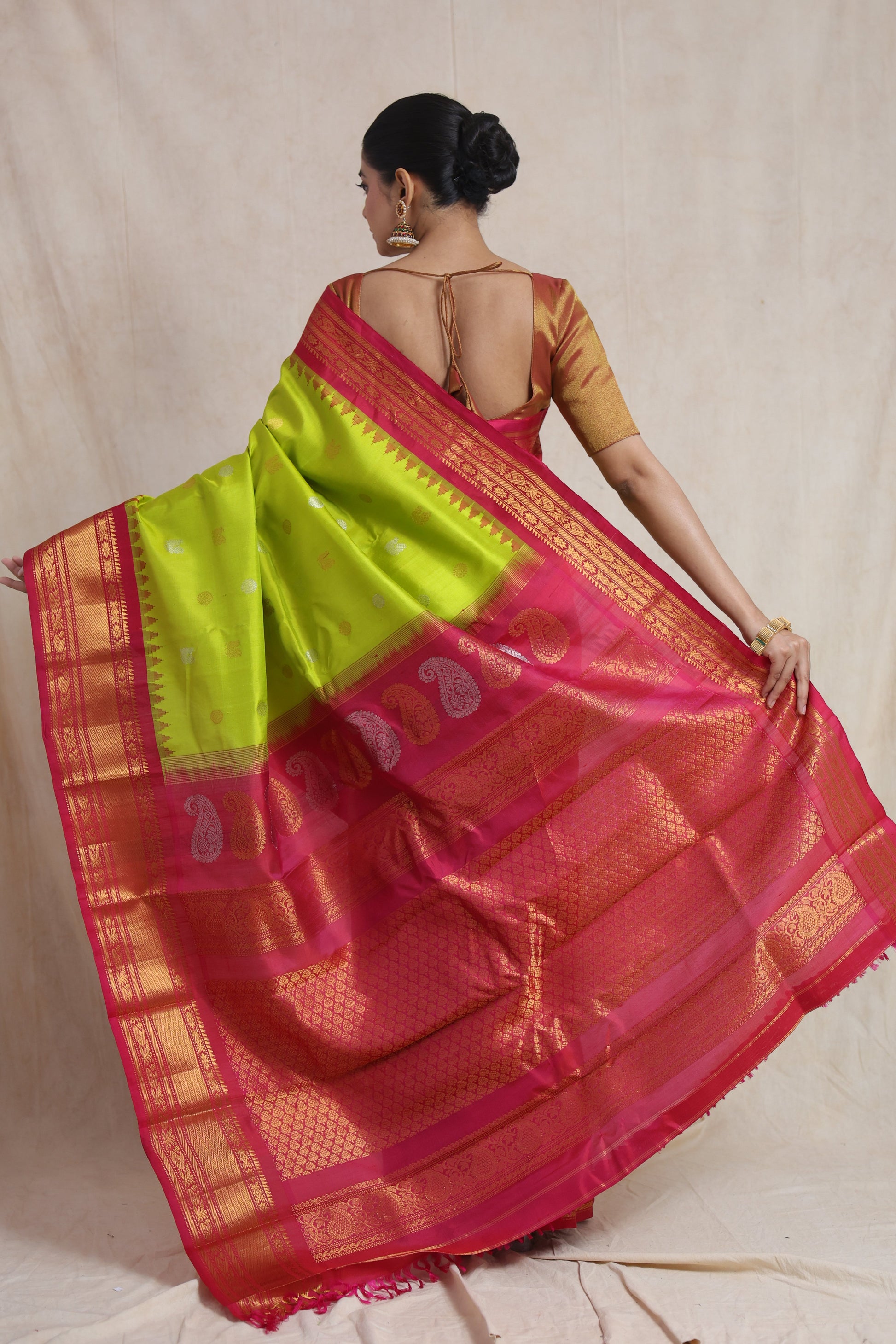 Back drape view of lime green Gadwal silk saree with paisley woven pallu