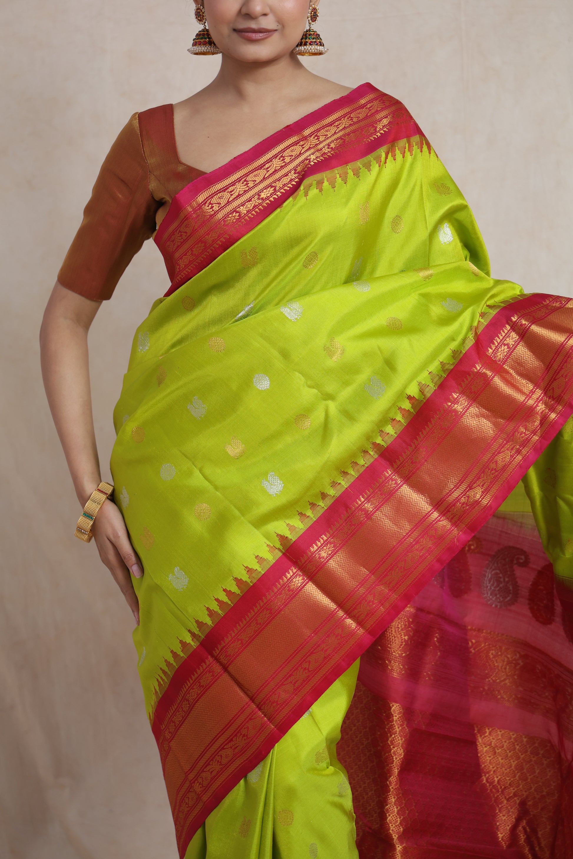 Border detail of lime green Gadwal silk saree with pink and gold zari weaving