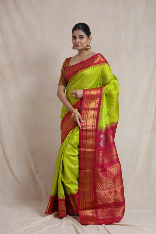 Elegant standing pose in lime green Gadwal silk saree with contrast pink border