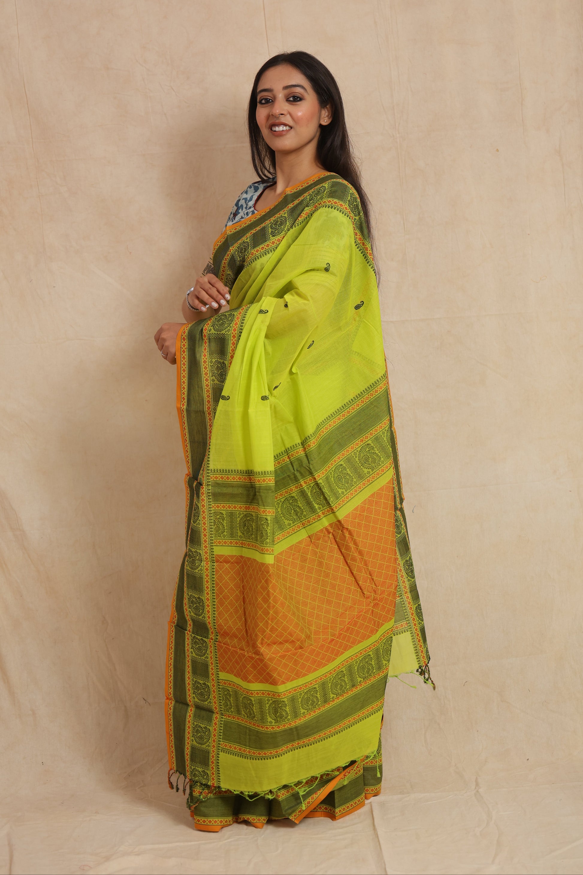 Side profile of lime green Kanchipuram cotton saree with contrast orange pallu