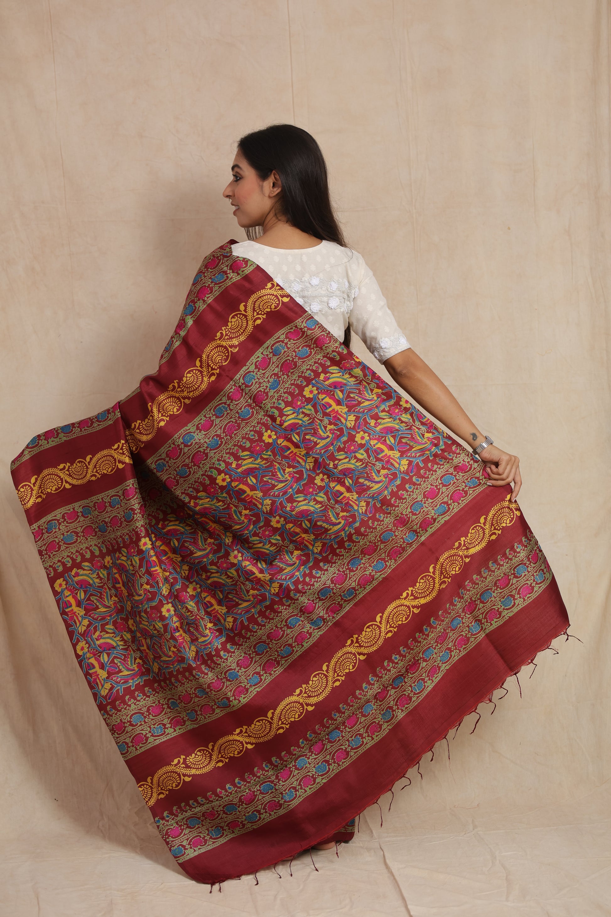 Back pallu view of deep maroon Batik silk saree featuring floral and bird-inspired artwork