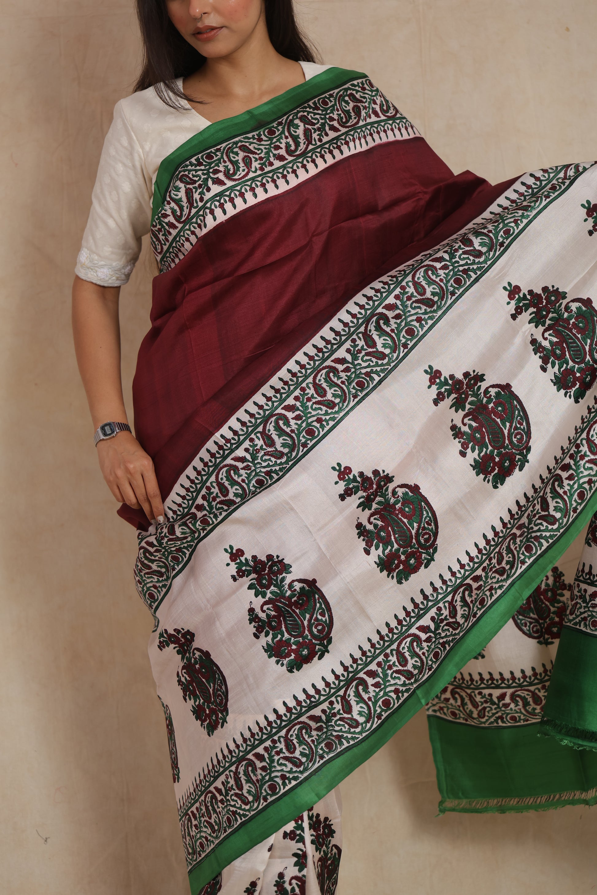 Close-up view of maroon Batik silk saree with paisley printed pallu and green border